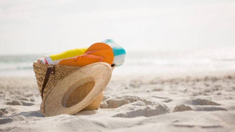 Saco com acessórios de praia mantidos na areia awesomecontent freepik ferias